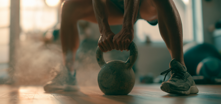 ** Athlet trainiert zuhause mit einer Kettlebell im Ganzkörper-Workout, Swing-Bewegung