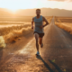 Läufer bei ruhigem Zone-2-Dauerlauf auf einer Landstraße im Morgenlicht, entspannter Ausdruck, gleichmäßiges Tempo