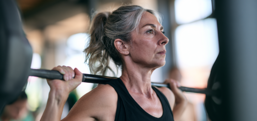 Frau um die 50 beim Krafttraining mit der Langhantel im Studio