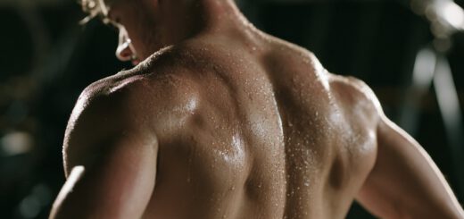 Verschwitzter Rücken eines Athleten nach einer intensiven Trainingseinheit im abgedunkelten Studio