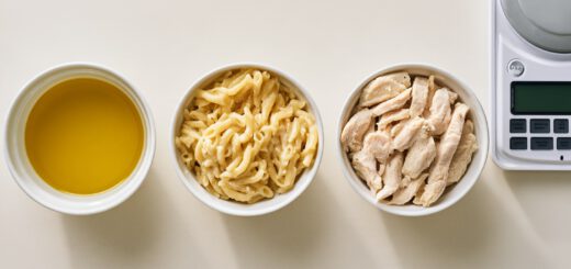 Drei Schälchen mit Öl, Nudeln und Hähnchenbrust nebeneinander auf einer Küchenwaage